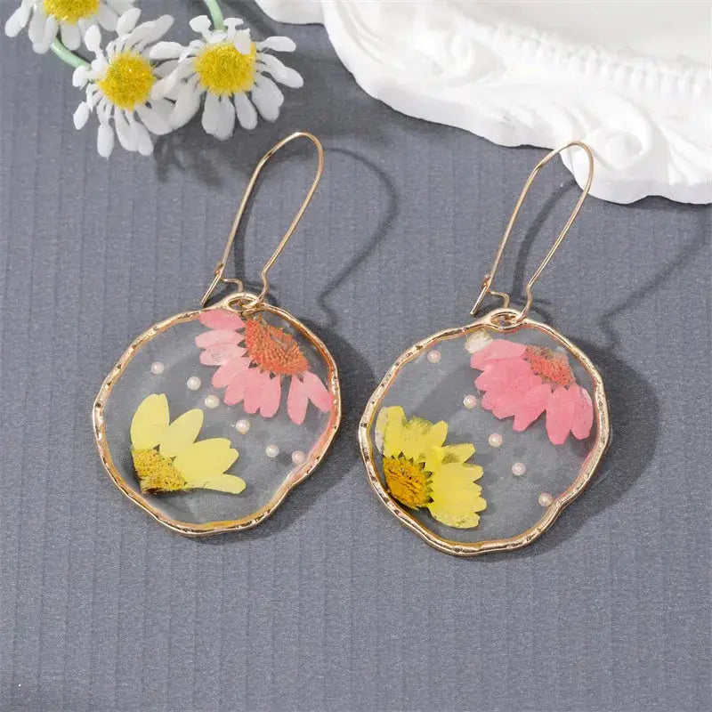Simples Market flower dangle earrings in clear epoxy resin with yellow and pink pressed flowers, gold-tone hoops (pair)