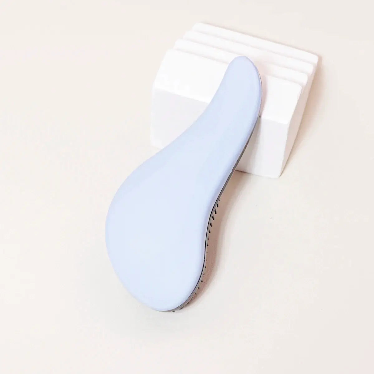 Antistatic massage brush with a light blue curved handle and black bristles for wet hair and real hair wigs