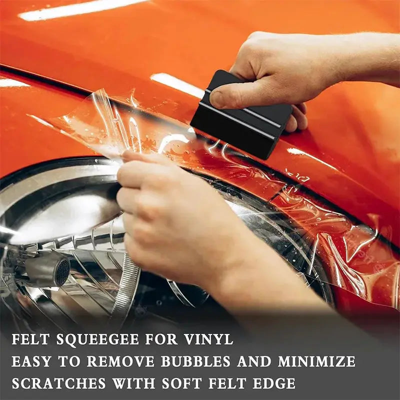 Felt edge squeegee for vinyl wrap; black plastic tool with soft felt edge smoothing film on red car by Simples Market