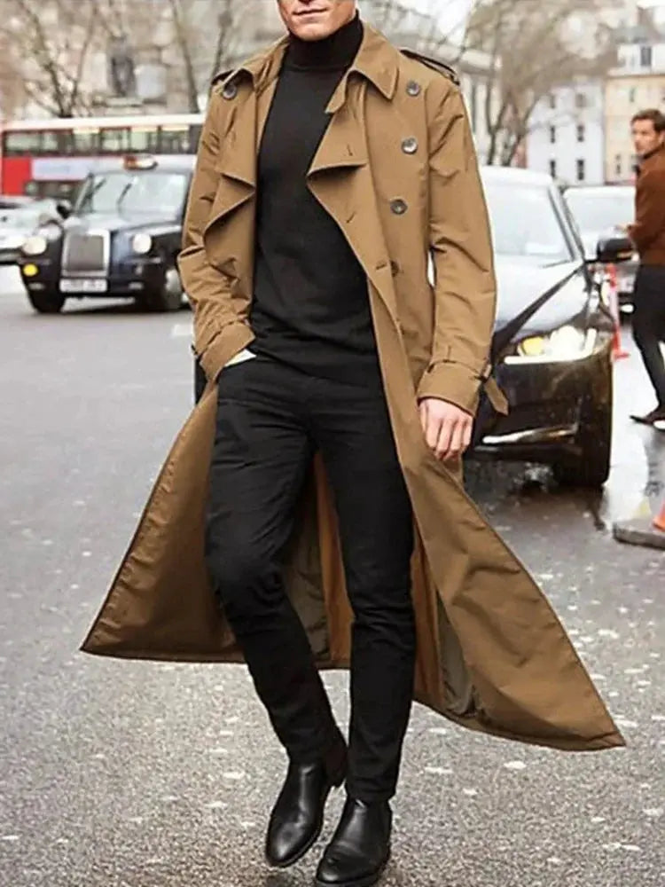 Men's tan trench coat by Simples Market, long overcoat with epaulets worn over black turtleneck and pants.