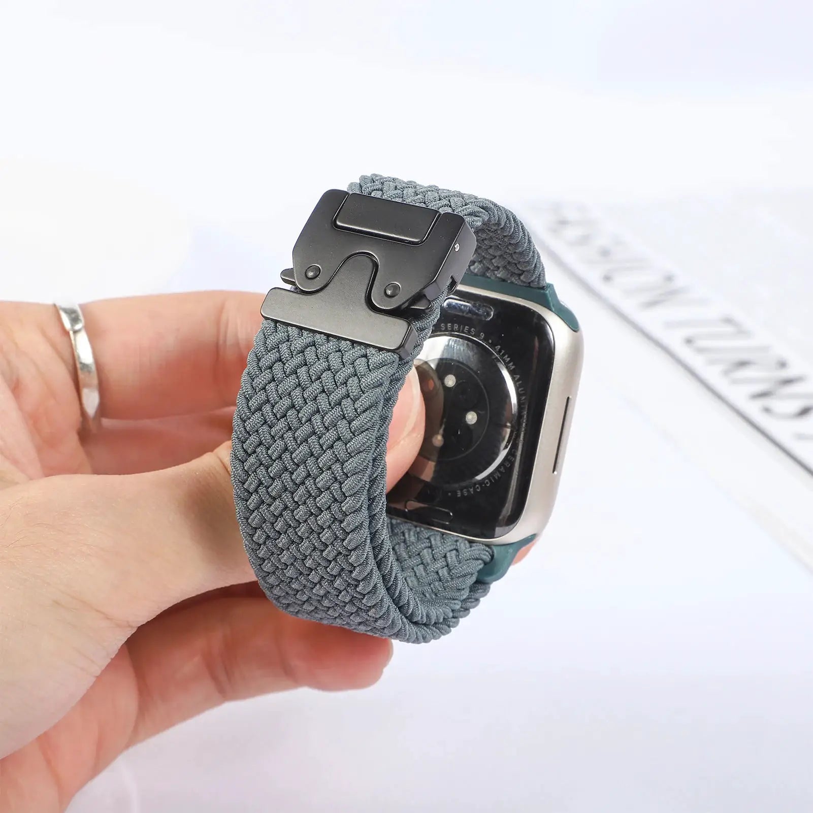Parachute braided Apple Watch strap in gray-blue nylon with a black metal buckle, fits 41–49mm.