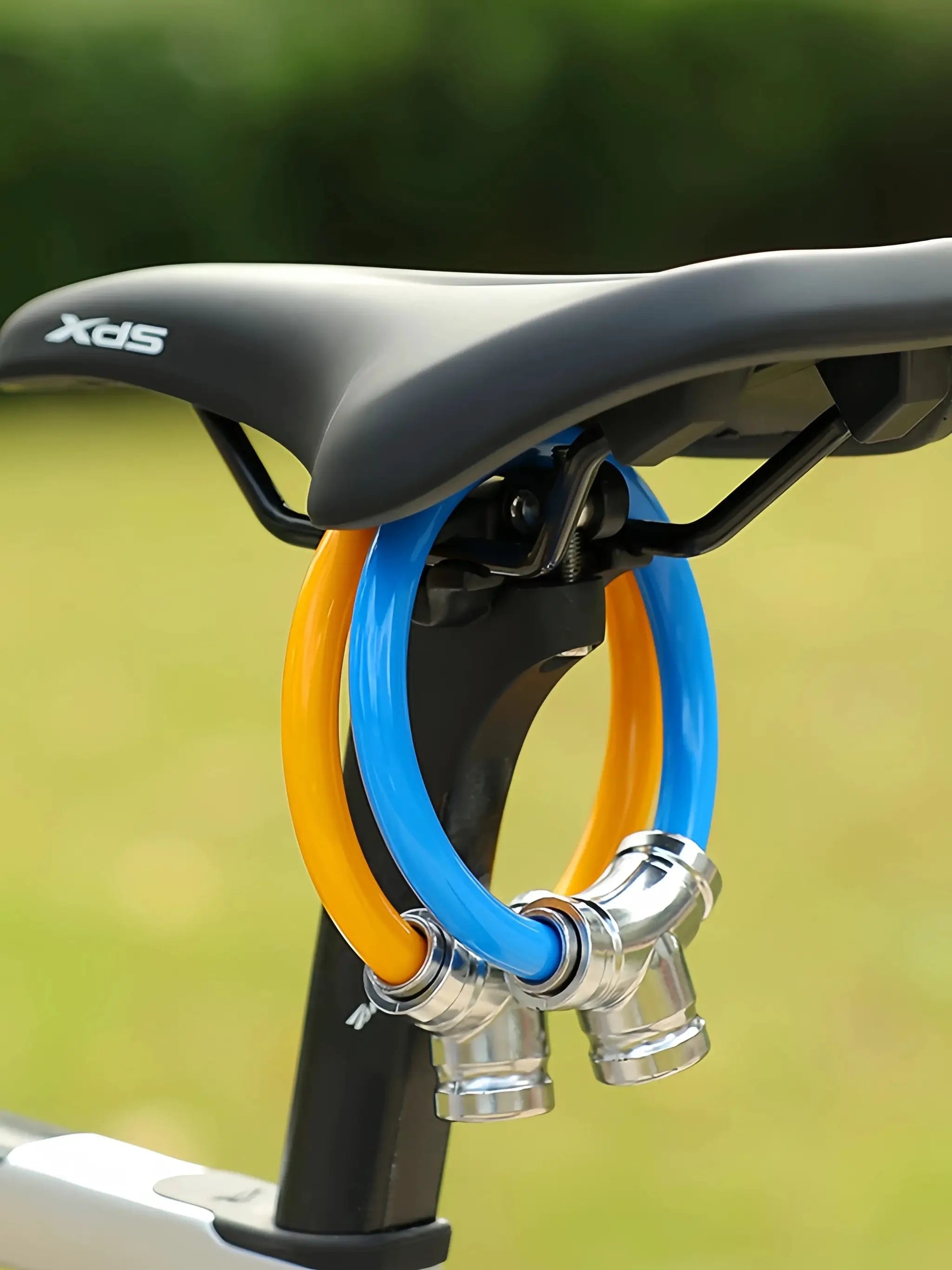 Bicycle lock with color-coated orange and blue steel cables attached near a bike saddle