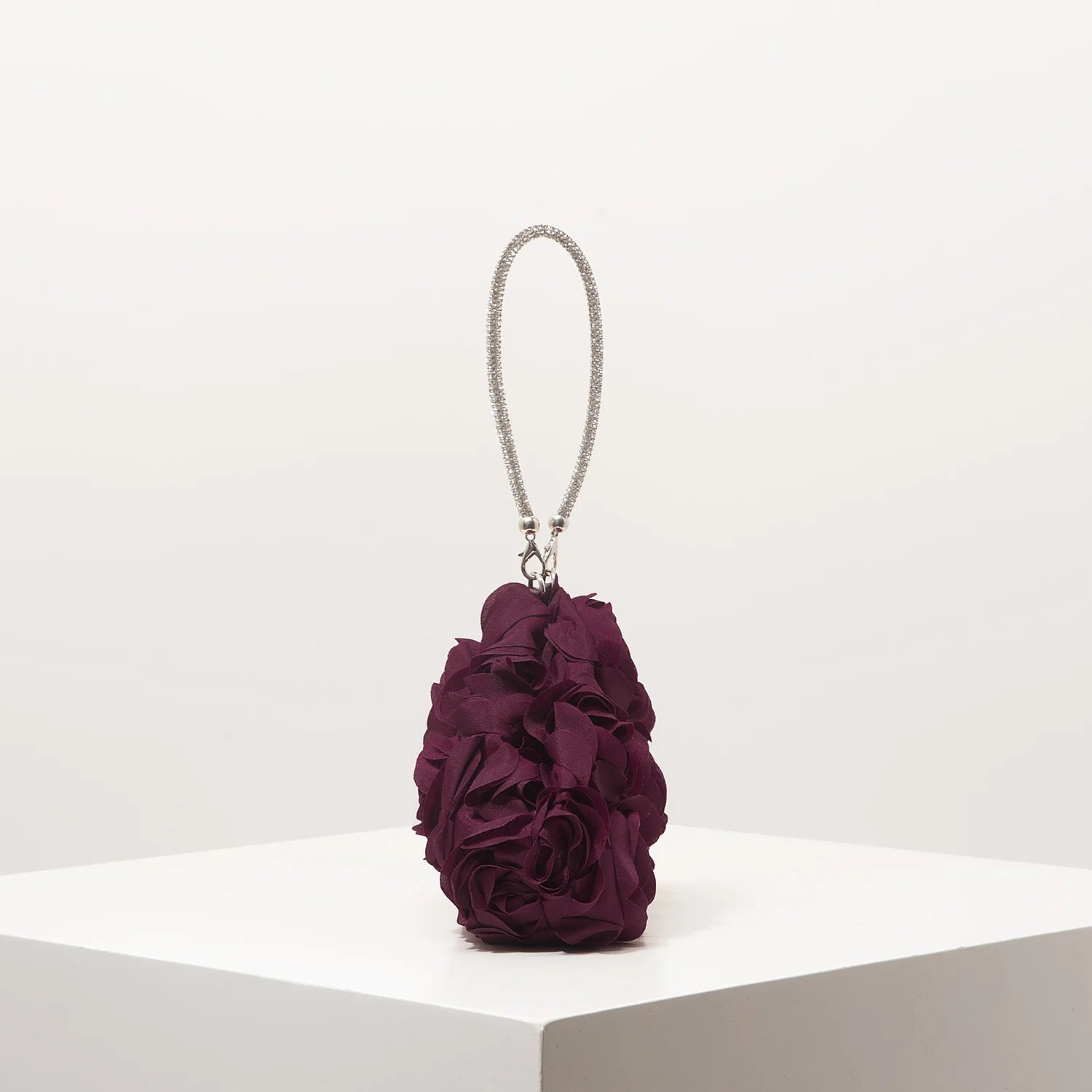 Mini purse with a silver rhinestone strap and a deep purple rosette flower body