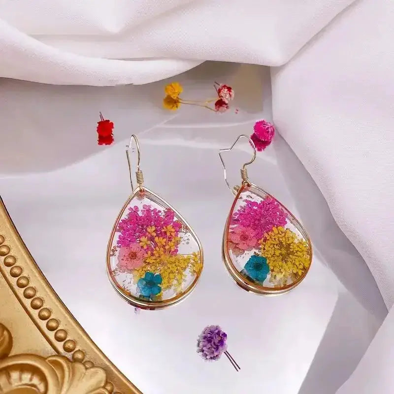 Teardrop epoxy resin flower earrings, colorful pressed blooms in gold-tone frames; Simples Market pair