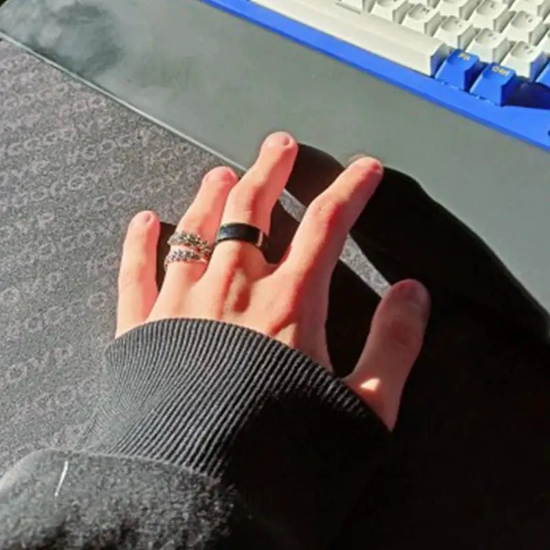 Smart stainless steel multifunctional ring for couples; two rings visible on hand, black band plus metallic ring.
