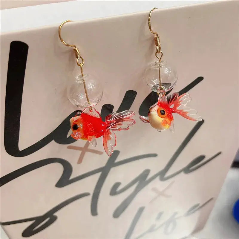 Goldfish pendant earrings by Simples Market; red koi fish charms with clear glass globe beads and gold hooks.