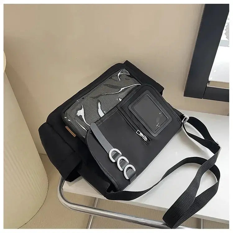 Y2K itabag in black with transparent front panel, badge display window, and adjustable crossbody strap