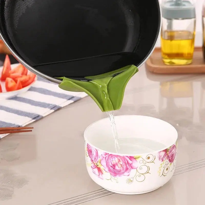 Green kitchen funnel with anti-splash edge pouring water into a floral ceramic bowl