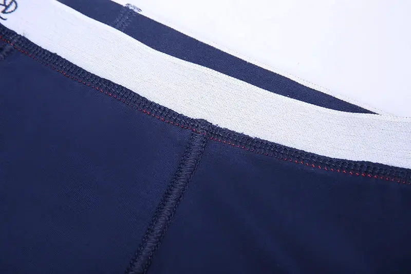 4-pack men's boxer shorts in navy cotton with white elastic waistband, close-up detail