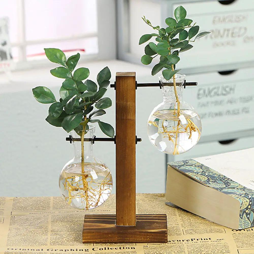 Creative Glass Desktop Planter Bulb Vase set on a wooden stand with two clear bulbs and greenery