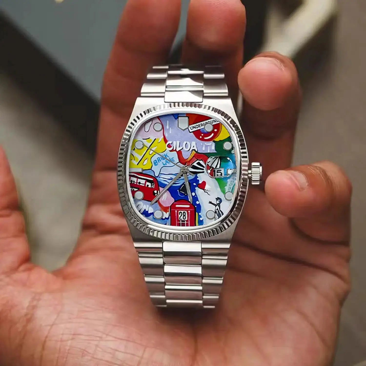 CILOA stainless steel men's wristwatch with colorful abstract dial, date window at 6, and brushed bracelet