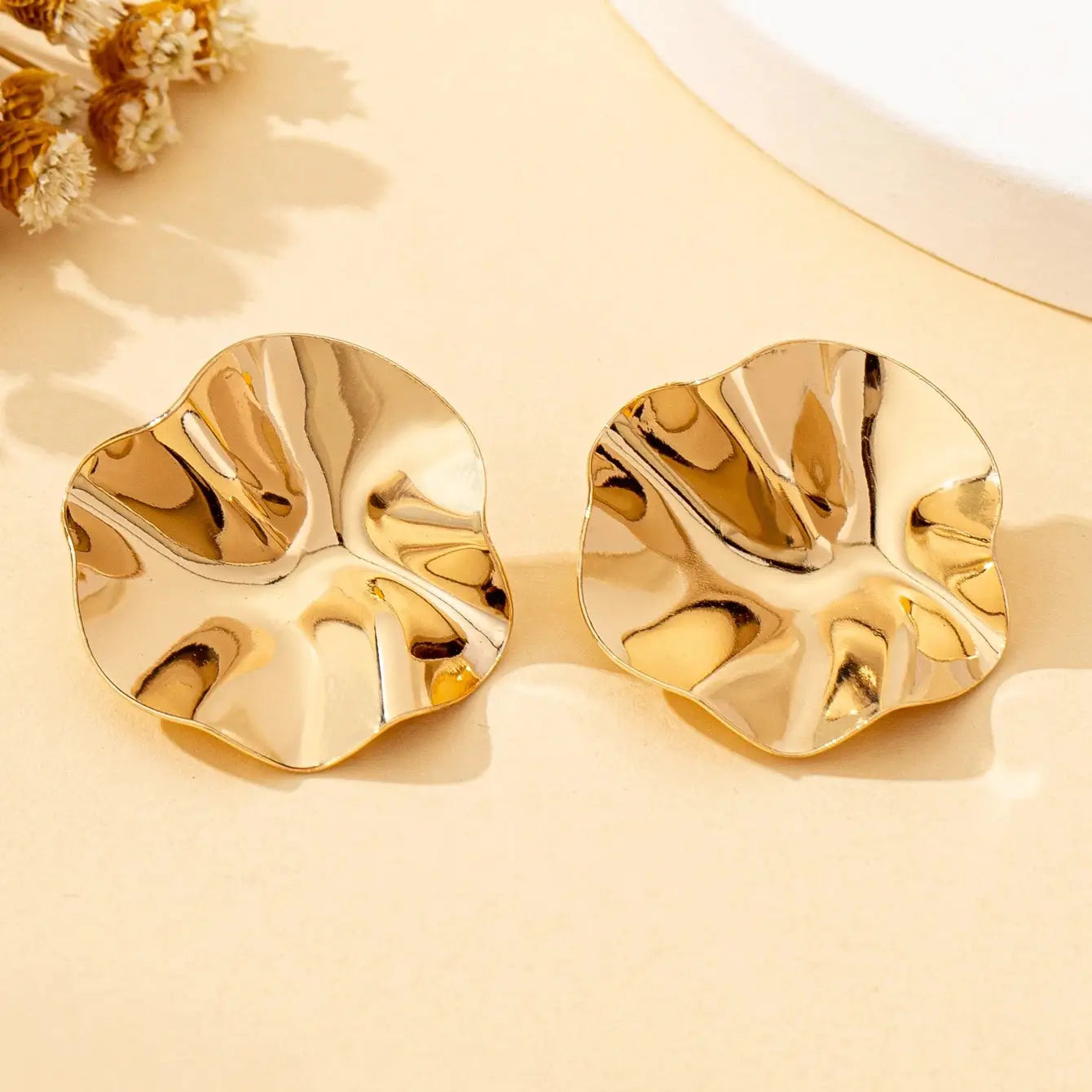Pair of irregular round gold-tone metal stud earrings by Simples Market