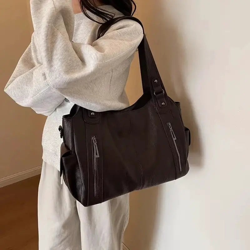 Shoulder bag in black PU leather with soft interior and dual front zipper pockets
