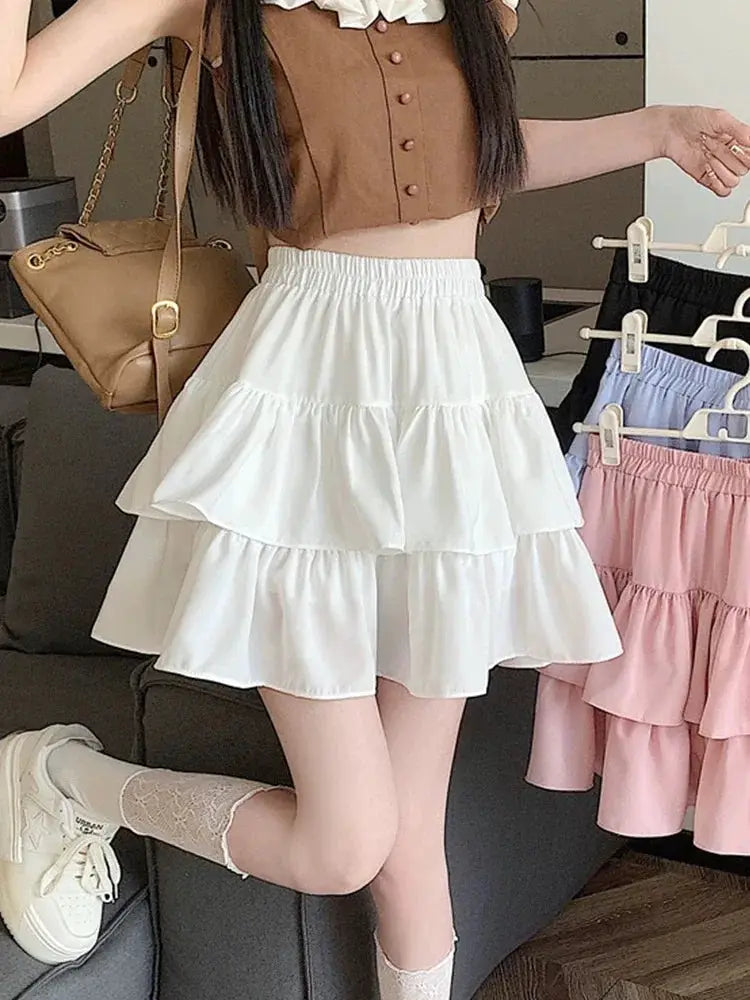 White tiered mini skirt by Simples Market with high-waist elastic waistband and ruffle layers; 3 pastel skirts visible.