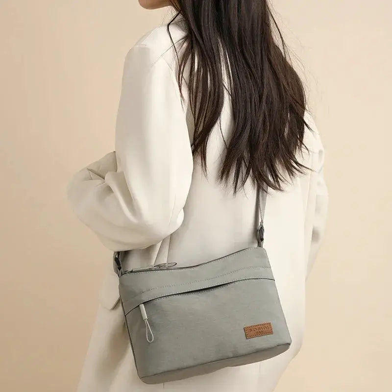 Canvas crossbody bag from Simples Market in gray with 3 main pockets and front zipper