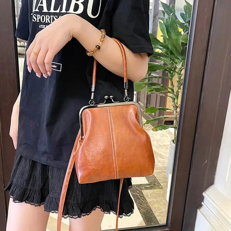 Vintage-style women's handbag in brown PU leather with a metal clasp frame and detachable crossbody strap.