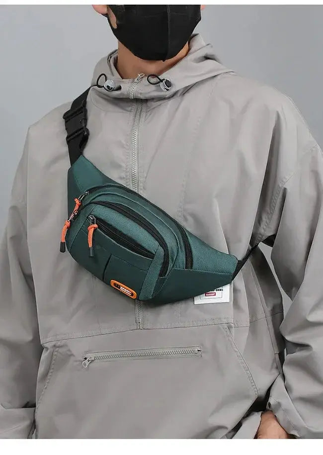 Oxford waterproof waist bag by Simples Market worn across chest in teal with orange zipper pulls.