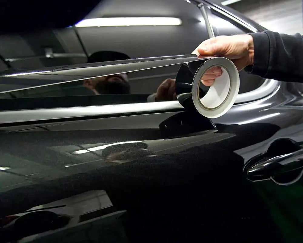 Glossy black vinyl wrap stripes for chrome-delete window trim on a car by Simples Market.