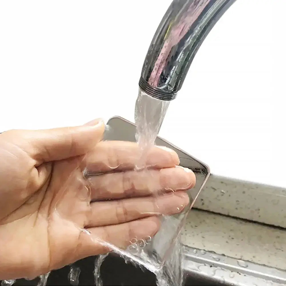Transparent silicone anti-slip mat being rinsed under a faucet in a kitchen sink