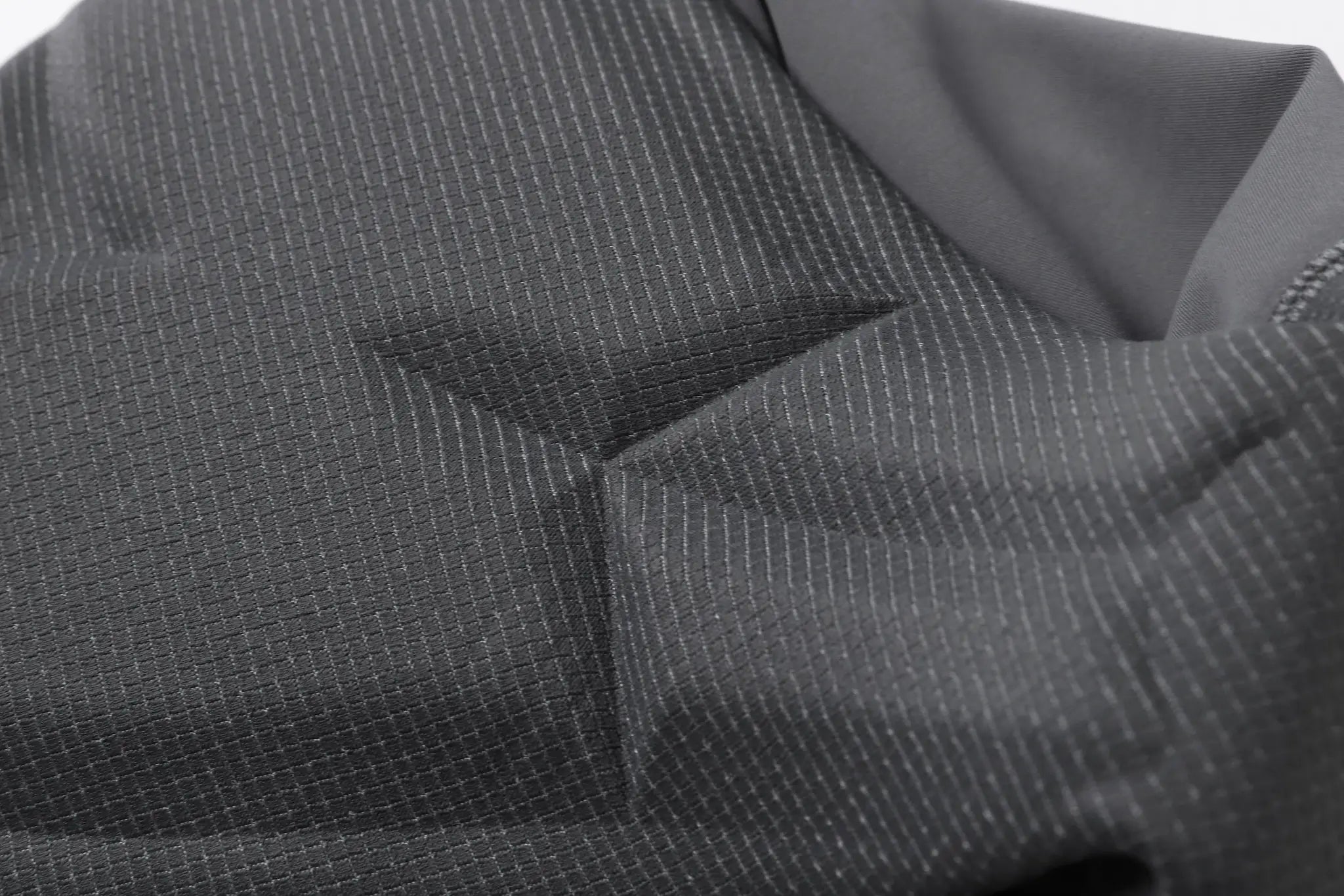 Cycling bib shorts fabric close-up in dark gray with fine pinstripe texture