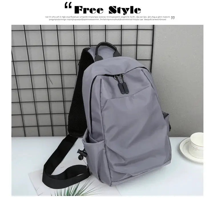 Gray canvas backpack crossbody bag with black zippers and straps