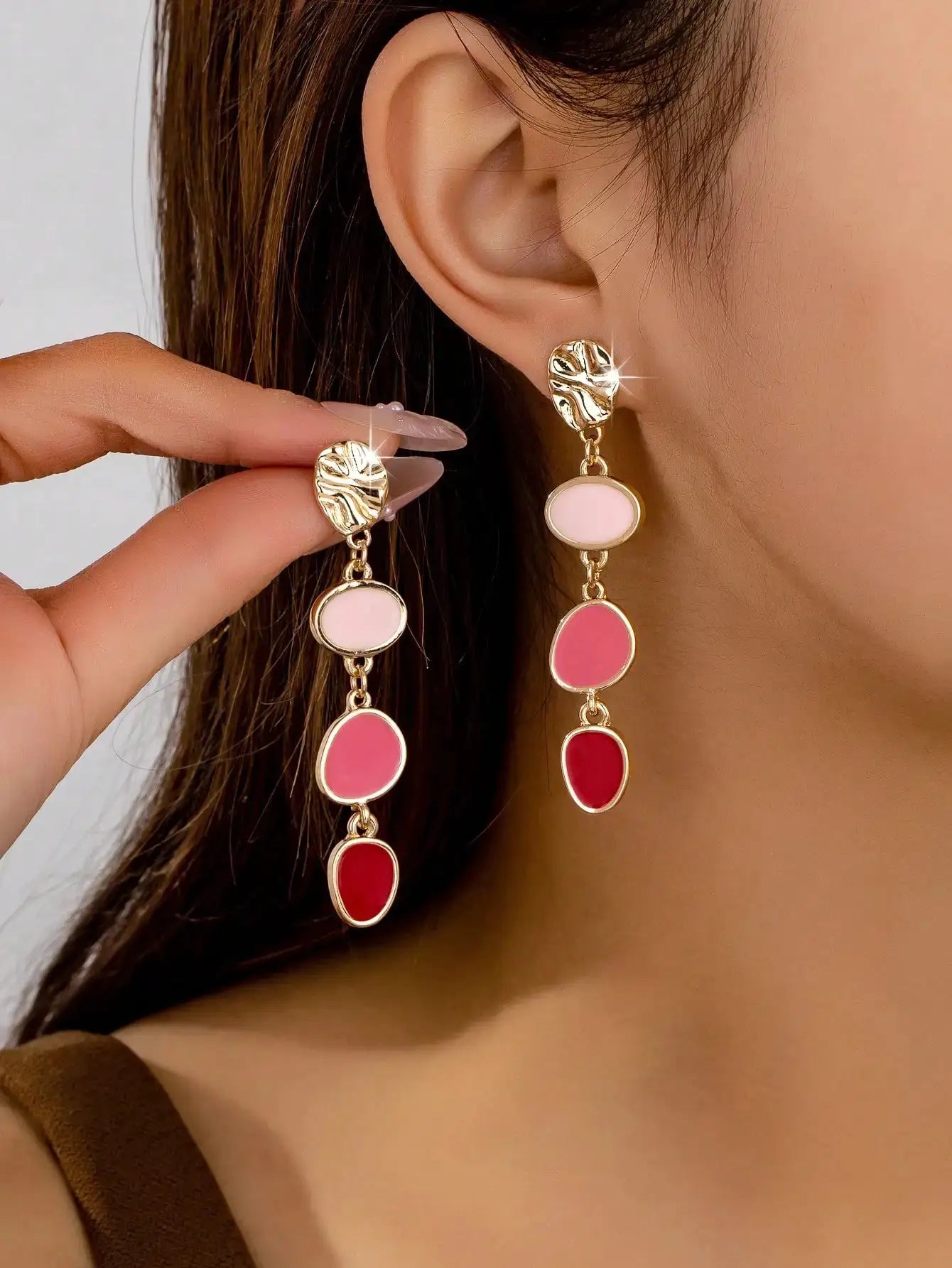 Gold-tone oil-drip earrings with pink and red oval stones; pair of long drop earrings.