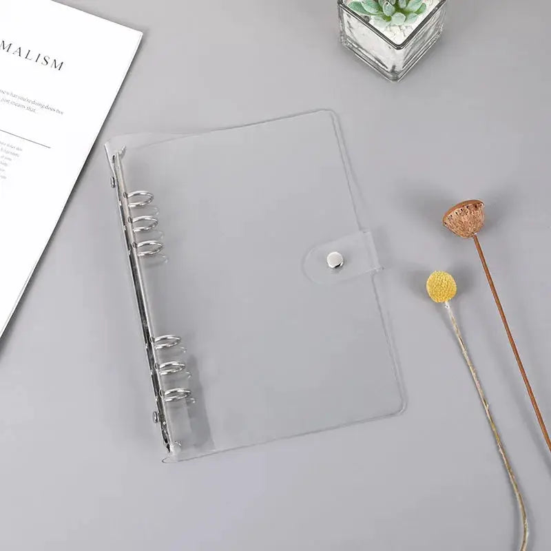 Transparent plastic ring binder with snap strap and six rings for A5/A6 notebooks