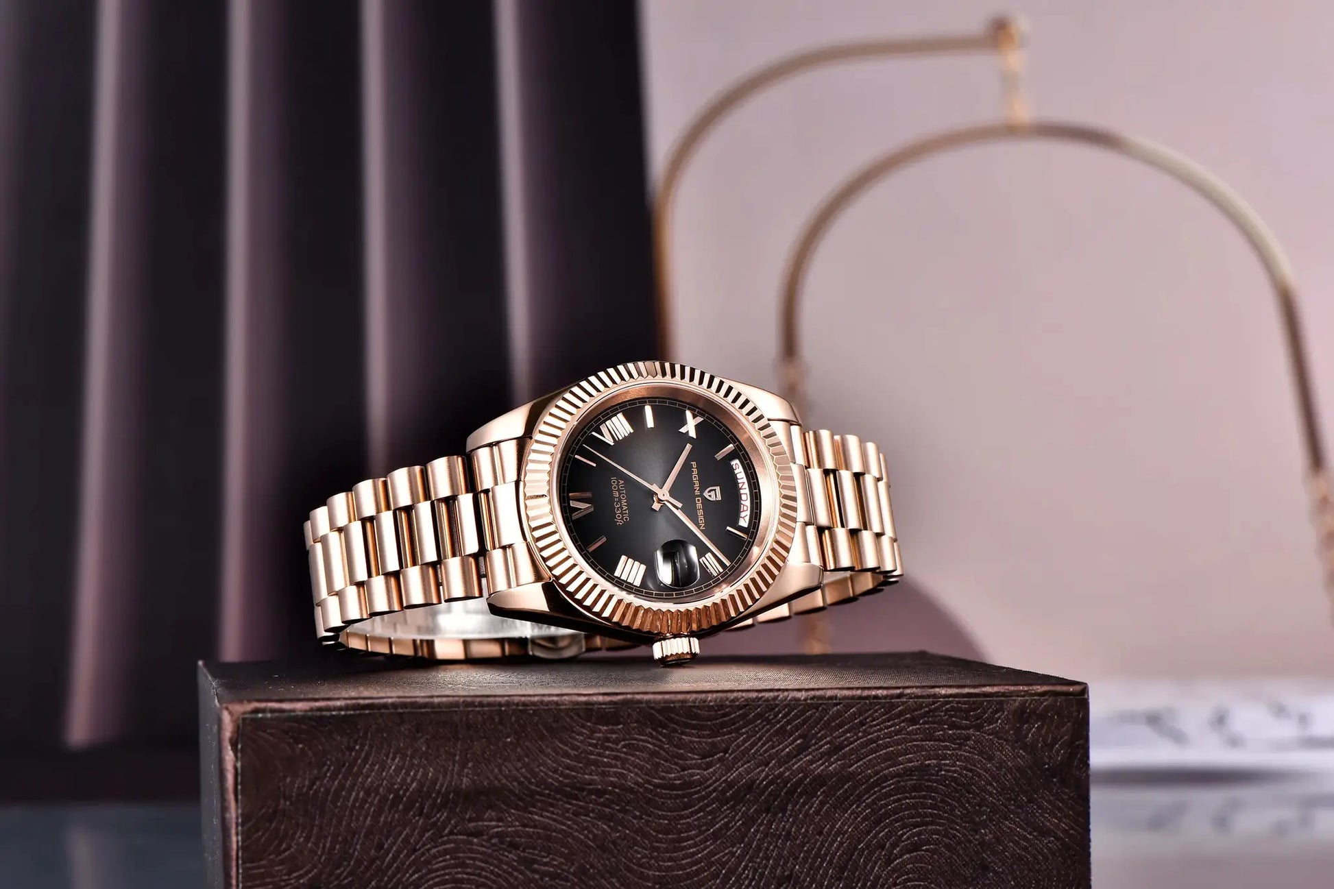 Pagani Design DD40 rose-gold automatic men’s watch with stainless steel bracelet resting on a dark display.