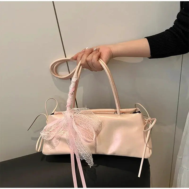 Pink satin square handbag with lace bow on the handle.