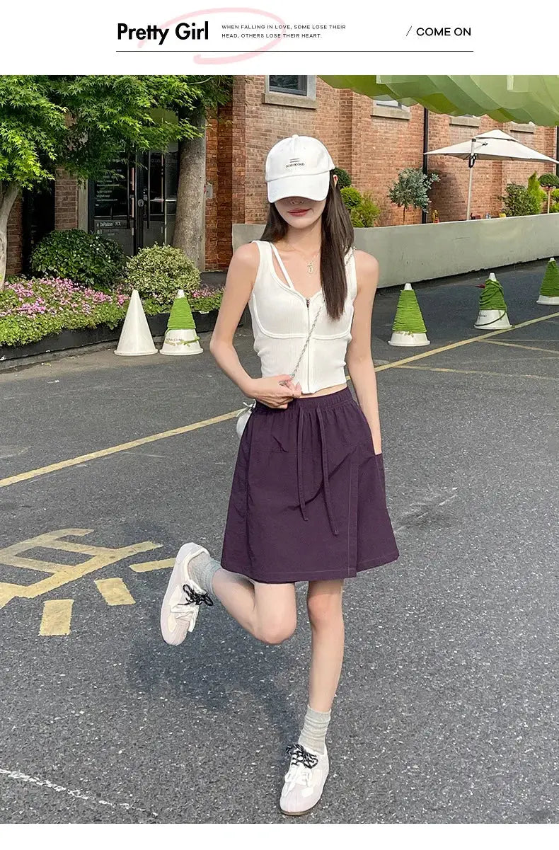 Fake 2-piece shorts-skirt set: white sleeveless zip-top with purple high-waisted A-line mini skirt, outdoor streetwear look