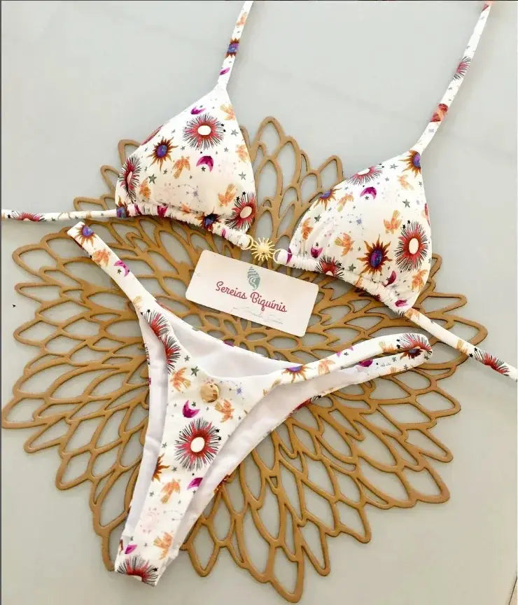 Print halter bikini set with thong bottoms; white fabric with colorful sunburst floral print.