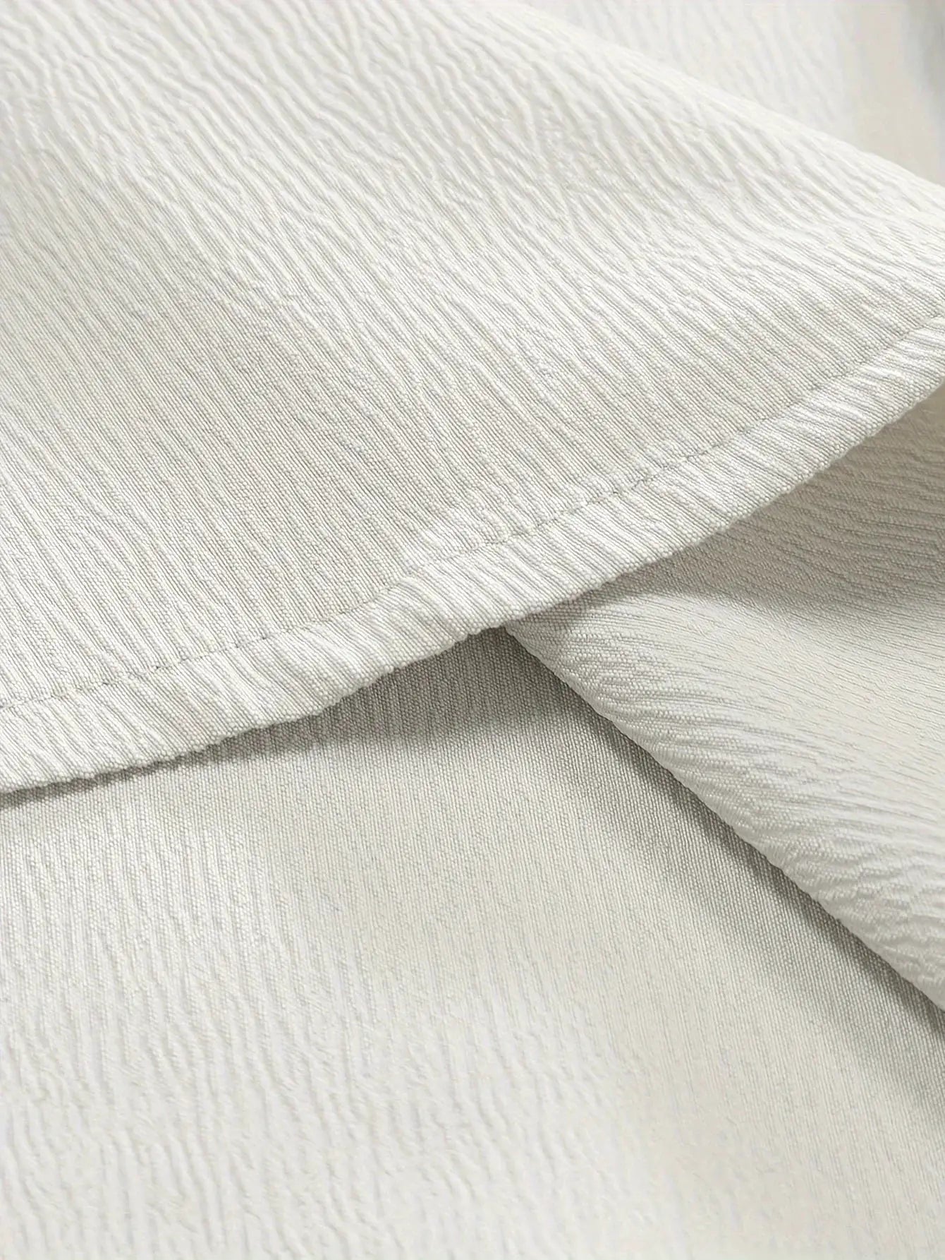 Men's linen shirt fabric close-up in beige, breathable textured textile