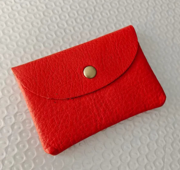Red genuine leather card holder with a snap-flap envelope-style closure, compact mini business card sleeve.