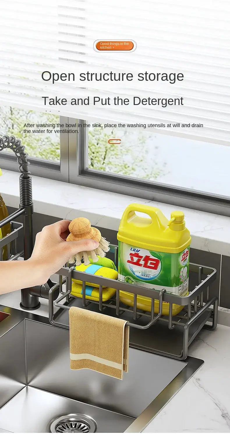 Stainless steel kitchen sink drain rack over sink with sponge, scrub brush, dish soap bottle, and towel