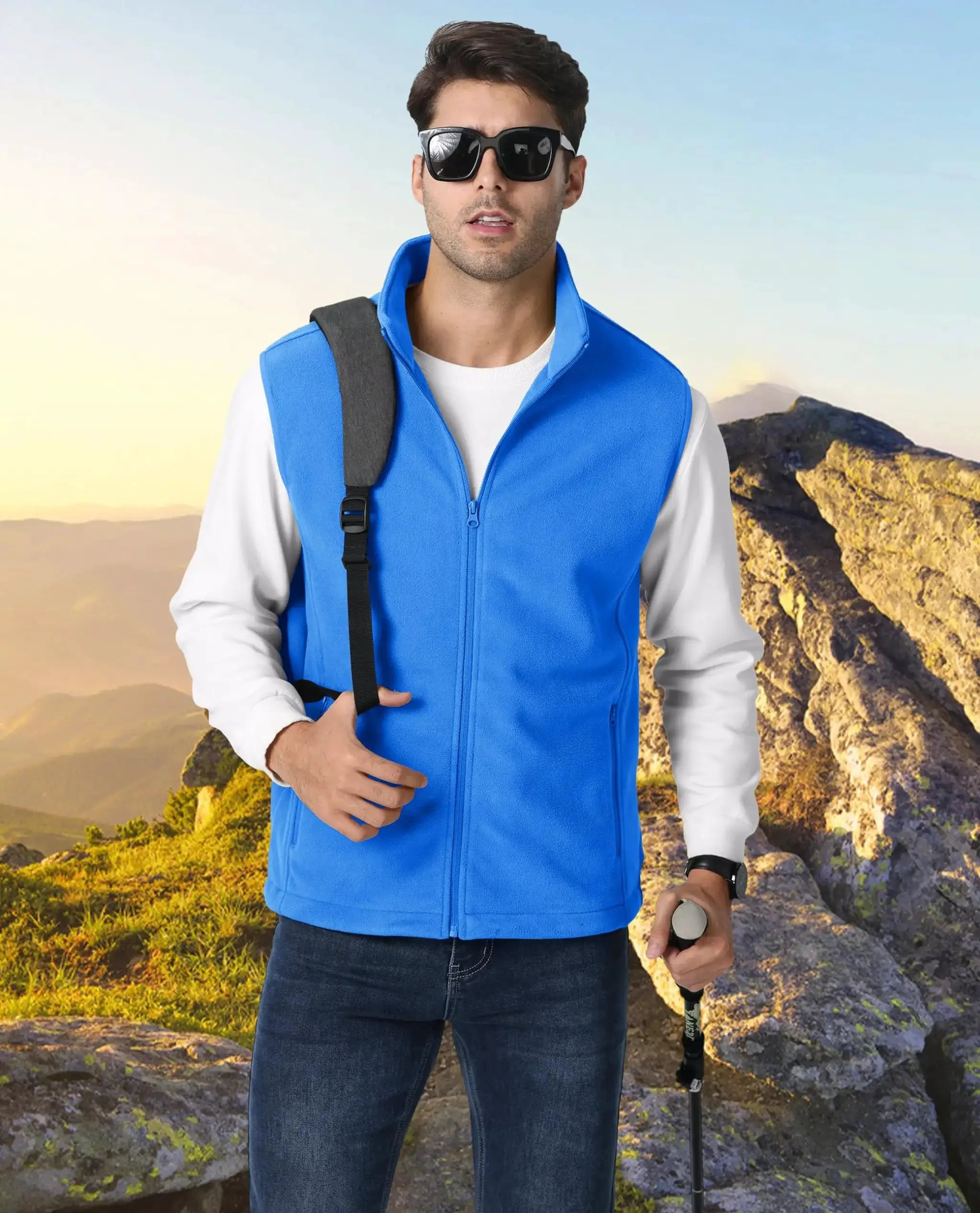 TACVASEN blue fleece vest jacket with stand collar worn by man hiking outdoors with trekking pole