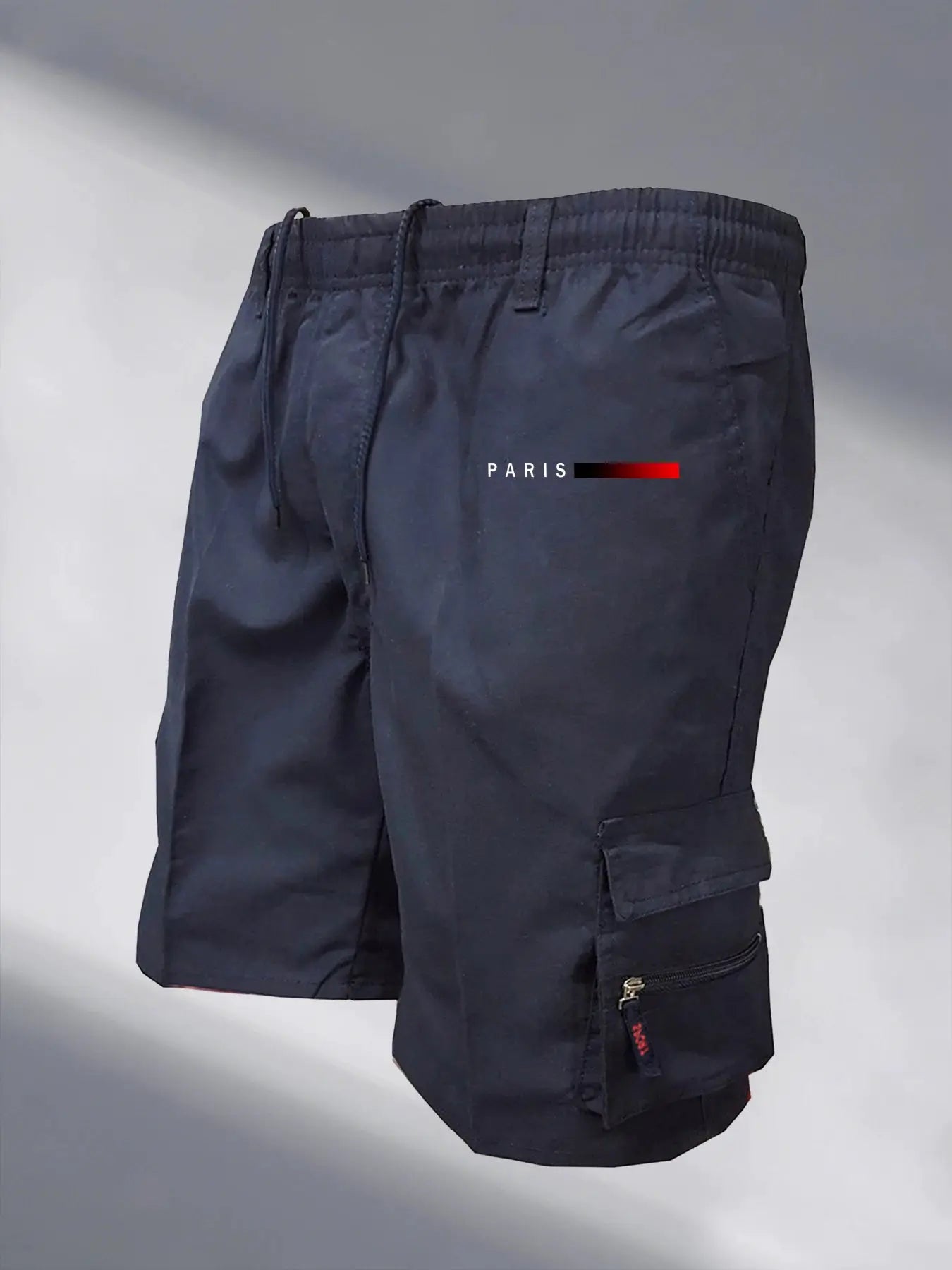 Men's navy tactical cargo shorts with elastic waist, drawstring, and side zip pocket, Paris logo accent.