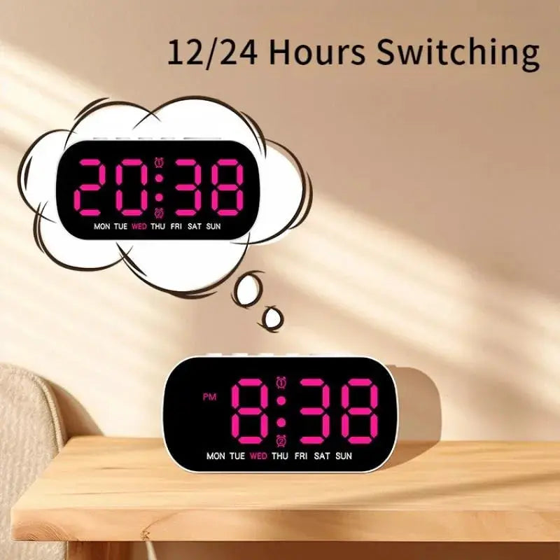 Digital alarm clock with pink LED display on a black body, placed on a wooden desk.