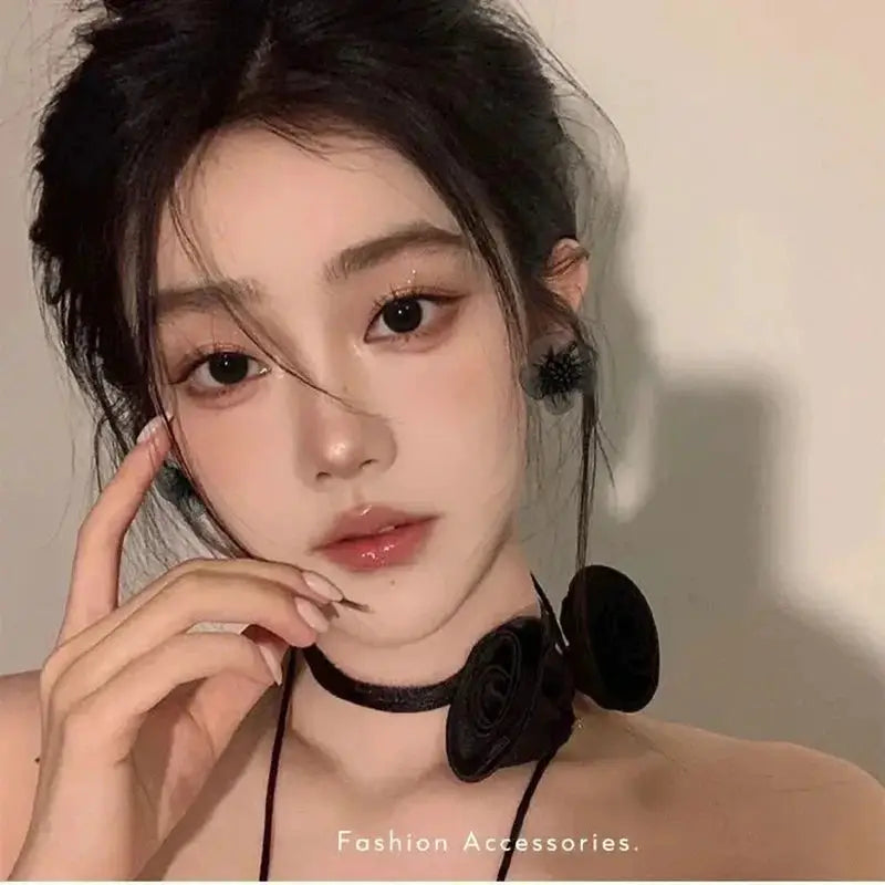 Black floral enamel earrings and rosette choker necklace set worn by model