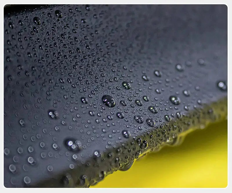 Plastic restorer for car plastics; glossy black finish with water droplets on the surface