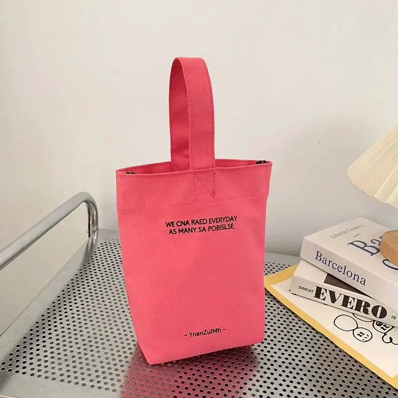 Pink canvas crossbody tote bag with long handles and large capacity.