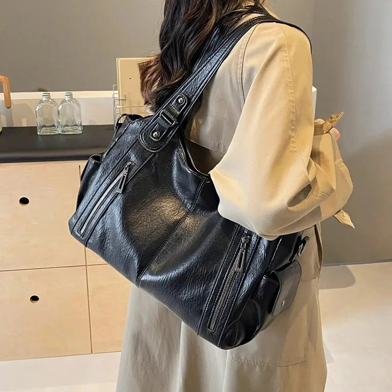 Shoulder bag in black PU leather with multiple zip pockets and adjustable strap
