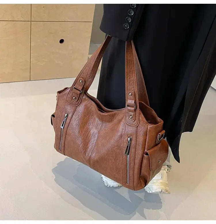 Brown PU leather shoulder bag with two top handles, dual front zippers, and side pocket