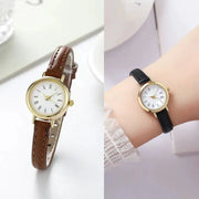 Two women's watches with gold-tone cases and leather straps (brown and black) featuring Roman numeral dials.
