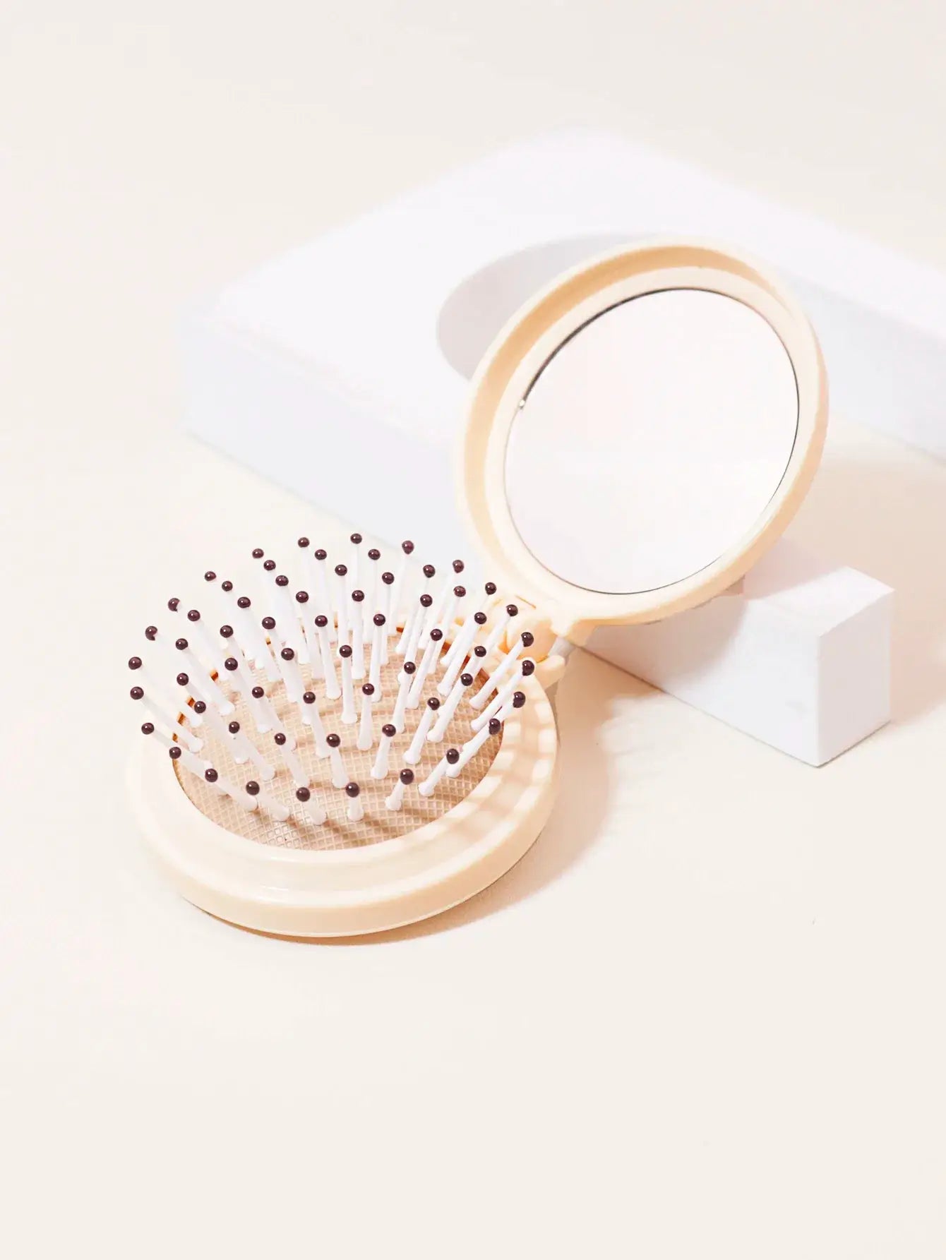 Mini folding mirror and anti-static travel hair brush, beige plastic; two-piece styling set.