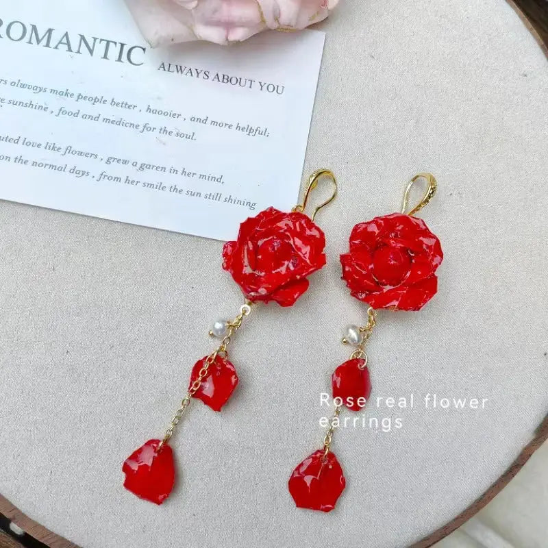 Earrings: red rose real flower long dangle with epoxy petals, gold hooks and pearl accents by Simples Market