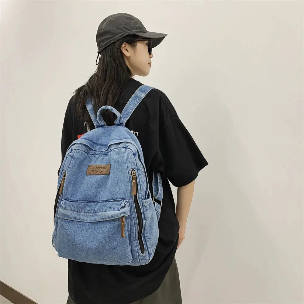 Blue denim school backpack with multiple pockets, large capacity worn by model