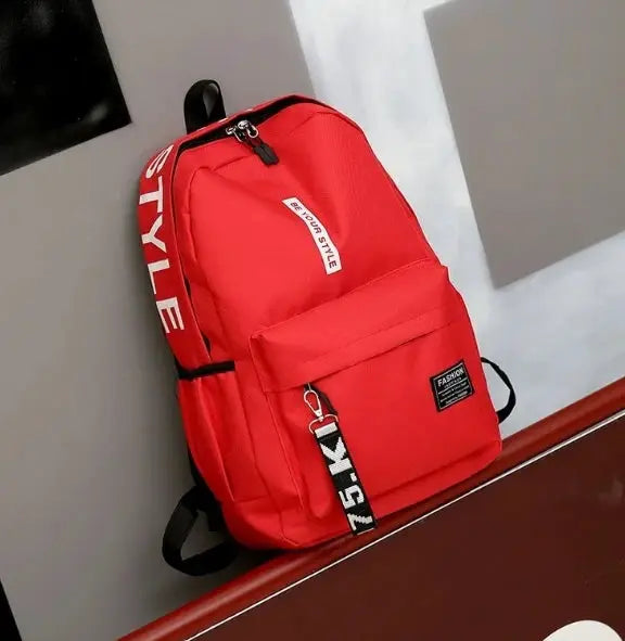 Red fashion backpack for students with front zip pocket and bold STYLE strap.