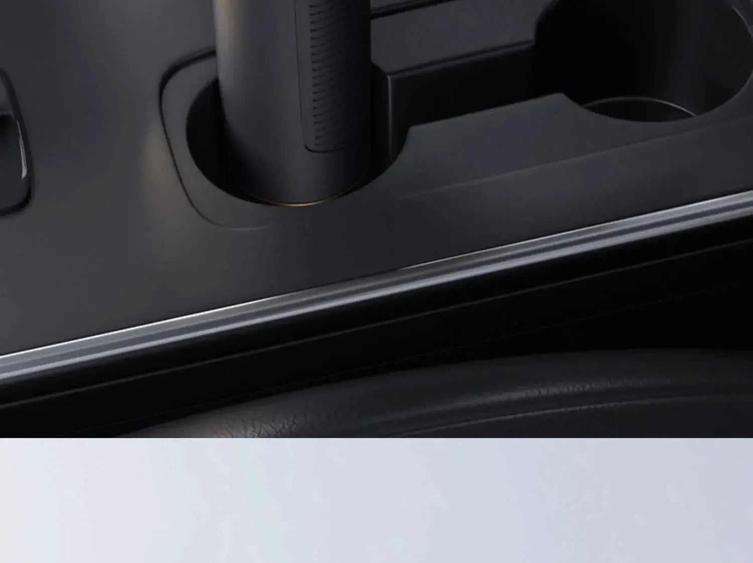 Portable wireless car vacuum cleaner, black handheld unit mounted in a car interior console