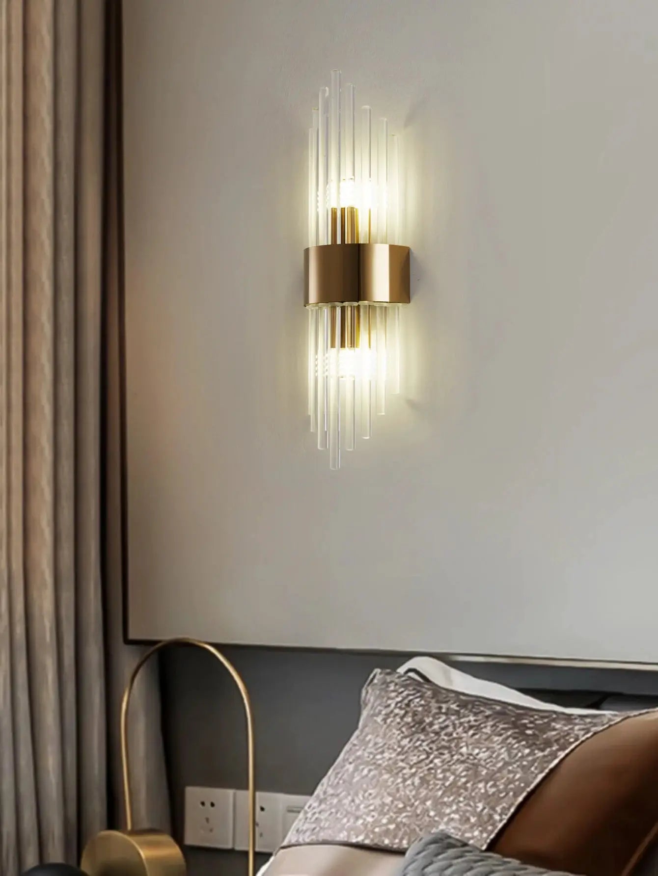 Gold brass crystal wall sconce with vertical glass rods mounted on wall
