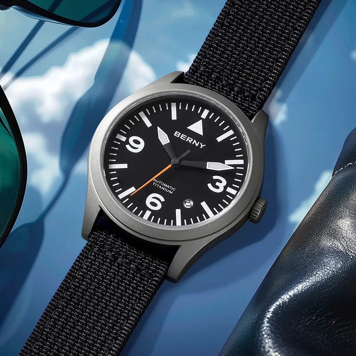 BERNY men's titanium automatic watch with black dial, white numerals, orange second hand, and black fabric strap
